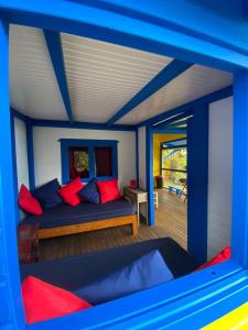 a room with a bed with red and blue pillows at Tamana Guadeloupe in Trois-Rivières