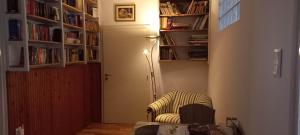 a living room with a chair and a book shelf at Bella Badacsony Apartmanház in Badacsonytomaj