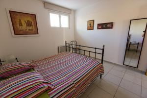 a bedroom with a bed with a colorful striped blanket at Mer et calme in Le Pradet