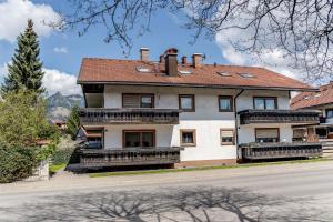 ein großes weißes Haus mit Balkon auf einer Straße in der Unterkunft TaLu Ferien Wohnung Sonthofen in Sonthofen