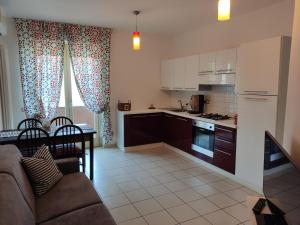 a kitchen and living room with a couch and a table at Lillananna Reload in Porto SantʼElpidio