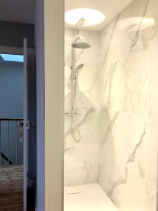 e bagno con doccia e pareti in marmo bianco. di Maison et jardin à Epernay centre ville a Épernay Altre 48 foto