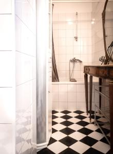 a bathroom with a shower and a black and white checkered floor at Apartman Pergola in Betina