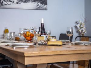 a wooden table with glasses and plates and wine bottles at Duplex rénové à Tignes · Accès direct pistes · Cheminée · WIFI · Animaux acceptés - FR-1-502-482 in Tignes +10 photos