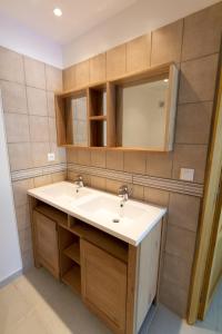 een badkamer met een wastafel en een spiegel bij Mer et calme in Le Pradet