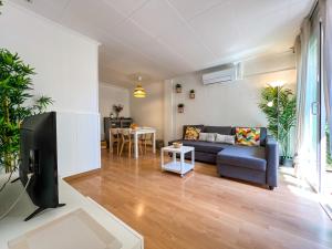 a living room with a couch and a tv at Vivalidays Albert - Calella - in Calella