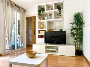 una sala de estar con TV en un centro de entretenimiento blanco en Vivalidays Albert - Calella - en Calella