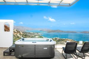 een hot tub op een patio met uitzicht op de oceaan bij Adrakos Apartments (Adults Only) in Elounda