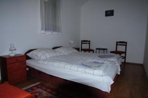 1 dormitorio con 1 cama con 2 sillas y 1 mesa en Beppe Vendégház, en Abaliget