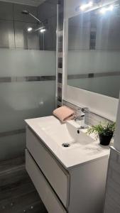 a white bathroom with a sink and a mirror at Apartamento Ocean in Corralejo