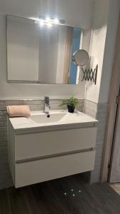 uma casa de banho com um lavatório branco e um espelho. em Apartamento Ocean em Corralejo