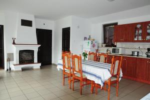 a kitchen with a table and chairs and a fireplace at Beppe Vendégház in Abaliget