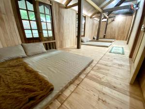 a large bed in a room with wooden floors and windows at Chipau house Trạm Tấu in Cham Ta Lao