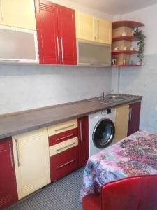 cocina con armarios rojos y lavadora en Casita, en Vaslui