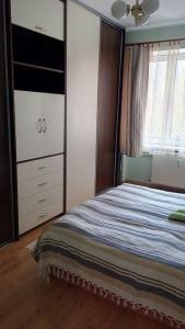 ein Schlafzimmer mit einem Bett, einer Kommode und einem Fenster in der Unterkunft Apartment Letna near the city center in Košice