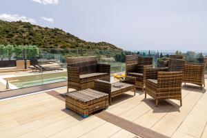 un grupo de sillas de mimbre en una terraza con vistas en crabonaxa suites, en Villasimius