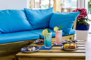 una mesa de centro con platos de comida en un sofá azul en crabonaxa suites en Villasimius