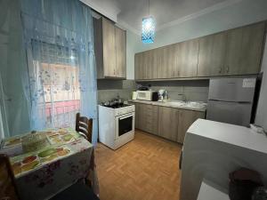 een keuken met een tafel en een fornuis top oven bij Sofi’s Apartment in Kavala