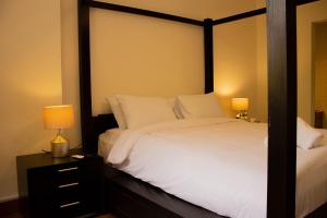 "Chez Riche" Luxury serviced apartment 12 في القاهرة: غرفة نوم بسرير ابيض كبير ومصباحين