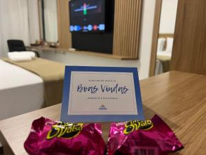 a picture of a hotel room with a sign on a table at Pousada Recanto Forte in Florianópolis