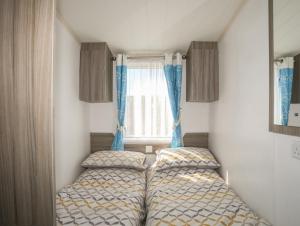 2 łóżka w małym pokoju z oknem w obiekcie The Caravan - Cilan w mieście Pwllheli