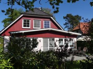 a red and white house with a red roof at Haus Marleen EG, FW 1 in Zingst