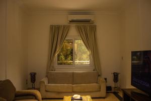 "Chez Riche" Luxury serviced apartment 12 في القاهرة: غرفة معيشة مع أريكة ونافذة