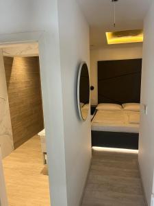 a small bedroom with a bed and a mirror at H&H Rooms Rovinj - Adults Only in Rovinj +24 photos
