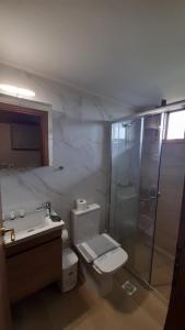 y baño con aseo, lavabo y ducha. en Villa Christina en Tolo