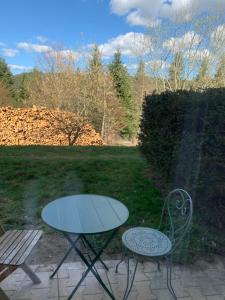 una mesa y dos sillas sentadas en un patio en Le Café Crème jardin parking, en Le Chambon-sur-Lignon