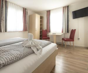 a hotel room with a bed and two red chairs at Gasthaus Traube in Bodman-Ludwigshafen