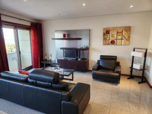 ein Wohnzimmer mit einem Sofa und 2 Stühlen in der Unterkunft Magnífico Apartamento T2 Praia de Esmoriz in Esmoriz