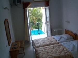 a bedroom with a bed and a view of a pool at Hotel Marlton in Skiathos