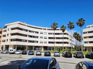 a parking lot with cars parked in front of a building at Magnífico Apartamento T2 Praia de Esmoriz in Esmoriz