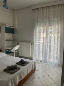 a bedroom with a bed with two towels on it at Fully Furnished Cozy Stay in Thérmi