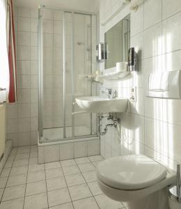 La salle de bains est pourvue de toilettes, d'un lavabo et d'une douche. dans l'établissement Gasthaus Traube, Ludwigshafen, Bodensee, Seenah gelegen, à Bodman-Ludwigshafen