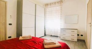 ein Schlafzimmer mit einem roten Bett und einer Kommode in der Unterkunft LA PETITE MAISON in Agrate Brianza