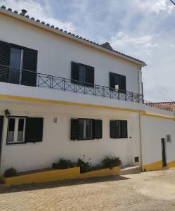 a white building with black shutters on it at Casa Xara in Proença-a-Nova