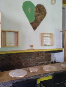 een tafel met borden en een hart aan de muur bij Casa Xara in Proença-a-Nova