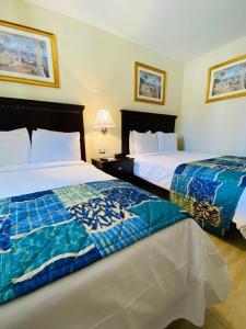 two beds sitting next to each other in a bedroom at Hotel Las Palmas Inn in Punto Fijo