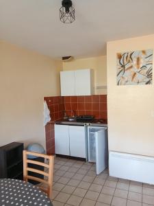 a small kitchen with a sink and a stove at MARGUERITE in Massiac