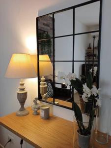 a desk with a lamp and a vase of flowers on it at Dom Apartment Luxury in Cagliari