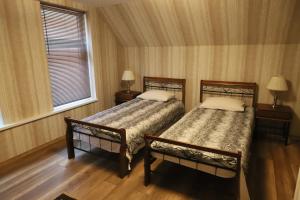 a bedroom with two beds and a window at Second Floor Apartament in Liepāja