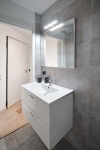 a bathroom with a white sink and a mirror at Xenia Apartments - Nuovo appartamento in zona tranquilla in Milan