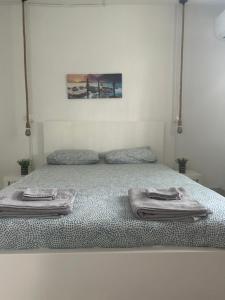 a bed with two towels on top of it at Avra House in Limassol