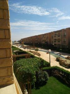 - une vue sur une cour avec un bâtiment et des buissons dans l'établissement شاليه بقرية كورنادو السخنه, à Ain Sokhna