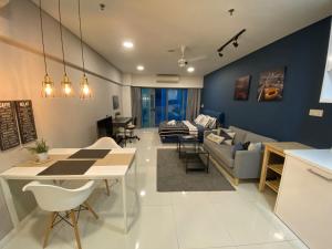 吉隆坡的住宿－Summer Suites KLCC By Whollmark，厨房以及带沙发和桌子的客厅。