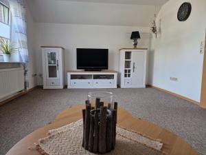 een woonkamer met een tv en een tafel bij Ferienwohnung Renken in Upgant-Schott