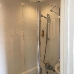 a shower with a glass door in a bathroom at Penzance Seaside studios in Penzance