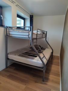 two bunk beds in a room with a wooden floor at Le Bronze, appartement de standing en hypercentre in Sarreguemines